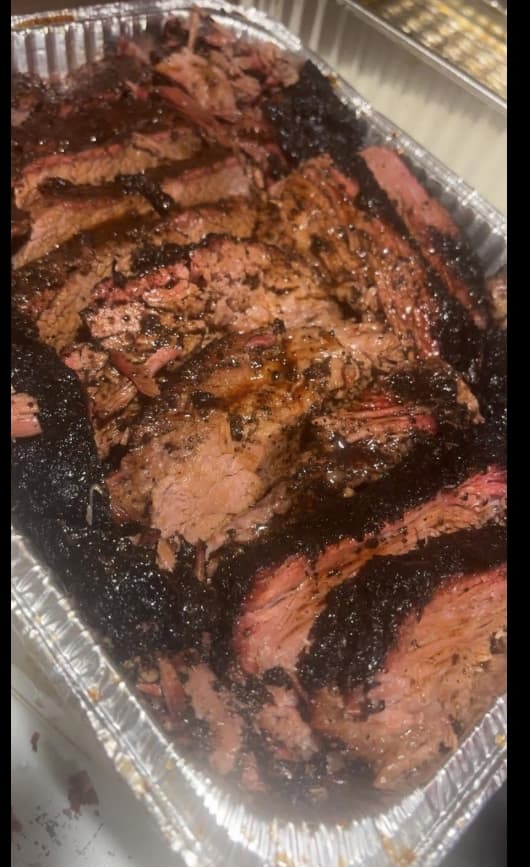 Sliced hardwood-smoked brisket fresh off the smoker