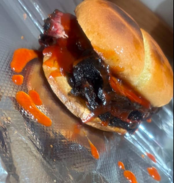 Chopped brisket sandwich on a toasted brioche bun with sauce